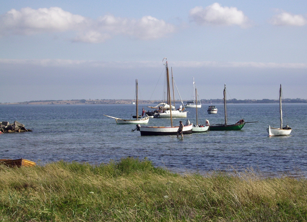 Daenemark Inselwelt kleine Holzboote vor Anker